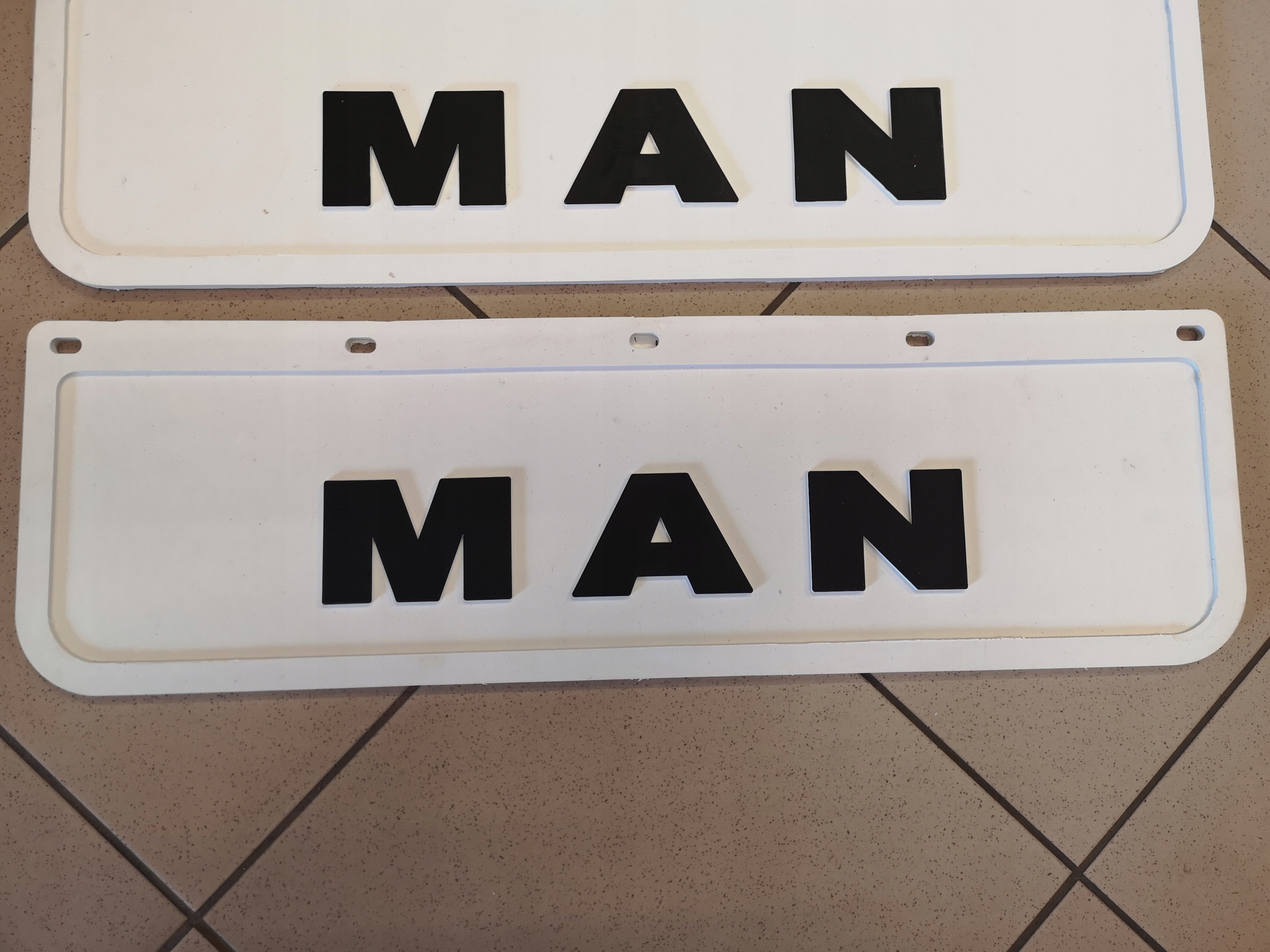 Chlapacz fartuch tłoczony MAN TiR biały - czarny 60x18cm Strona zabudowy przód + tył